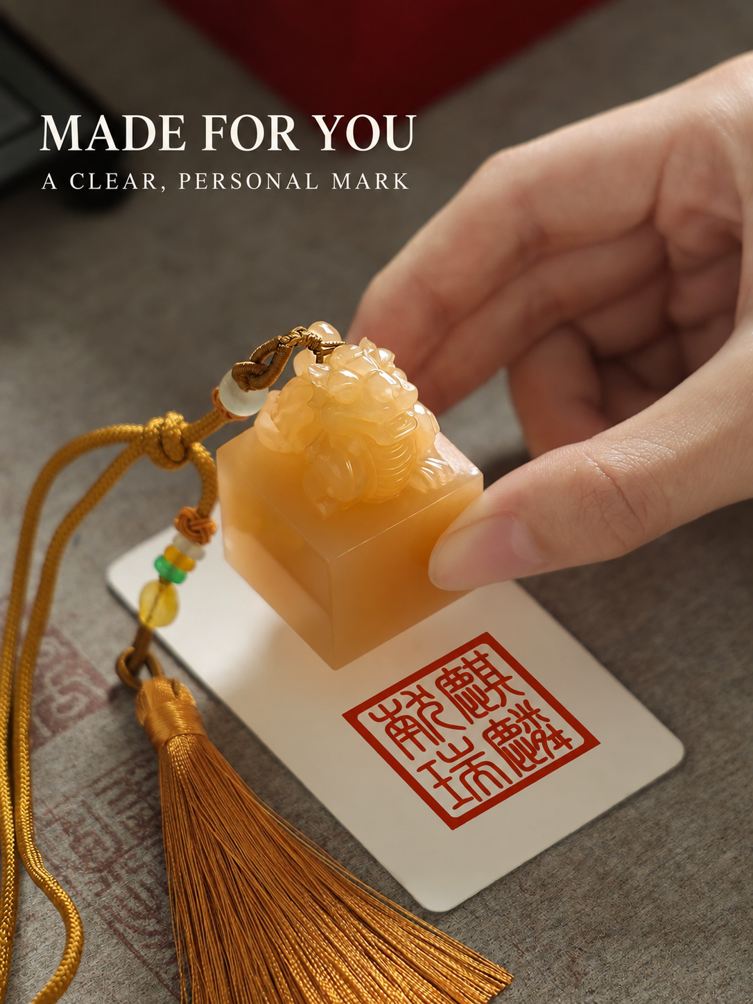 Hand pressing a personalized Chinese seal into red ink on paper